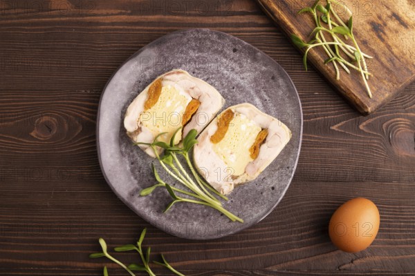 Chicken, egg and dried apricot meatloaf, microgreen on brown wooden. Diet, healthy eating. top view, close up