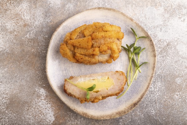 Chicken schnitzel on blue plate with microgreen on brown concrete. Diet, healthy eating. top view, copy space