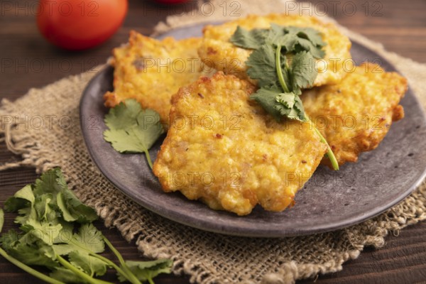 Fried crispy Chicken pancakes on brown wooden background and linen textile. side view, close up, selective focus