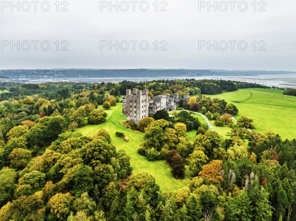 Autumn colours over Penrhyn Castle and Garden from a drone, Llandygai, Bangor, Gwynedd, North Wales, UK