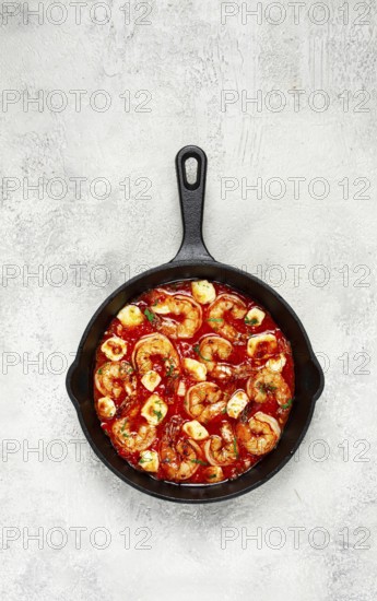 Greek saganaki, in an iron pan, saganaki with shrimp, shrimp in tomato sauce, with pepper and feta cheese, homemade, no people