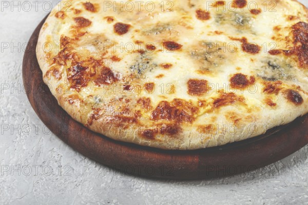 Freshly baked cheese pizza, white pizza, on a wooden plate, homemade, no people