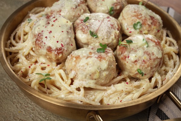 Spaghetti with chicken meatballs, with cream sauce, and parmesan cheese, and decorated with microgreens, homemade, no people