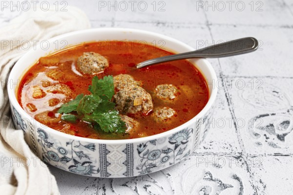 Romanian soup with meatballs, vegetable soup with meatballs, tiled table, homemade, no people