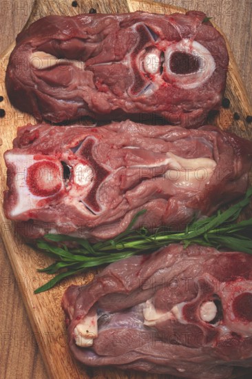 Raw steak, calf's neck on the bone, fresh meat, on the cutting board, top view, no people