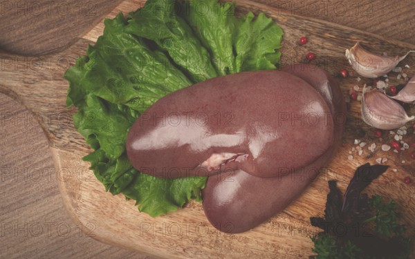 Raw pork kidneys, on a chopping board, close-up, top view, no people