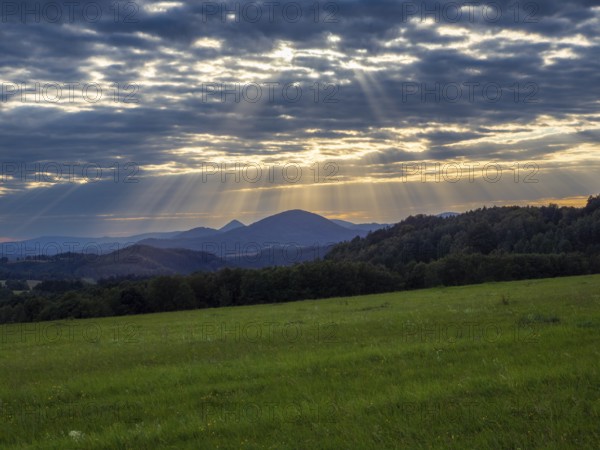Sunbeams over gentle mountain landscape and meadows, Bohemia, Lusetian Mountains, Czech Republic