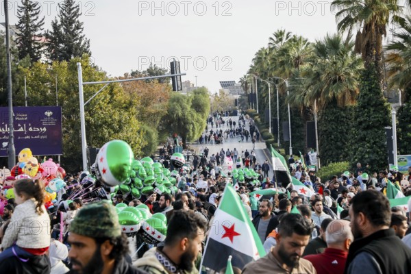 Damascus, Syria. November 28, 2025: Thousands of Syrians gather in Umayyad Square in central Damascus to celebrate the anniversary of the military operation that led to the fall of Bashar al-Assad's regime. Demonstrators express joy and unity while denouncing Israeli attacks on Syrian territory, Damascus, Damascus, Syria