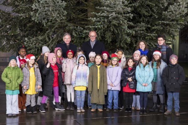 Friedrich Merz (CDU, Federal Chancellor of the Federal Republic of Germany) behind the Vocal Hero Children's Choir from Schöneberg elementary schools handing over the Christmas tree to the Federal Chancellery, Berlin, 28.11.2025