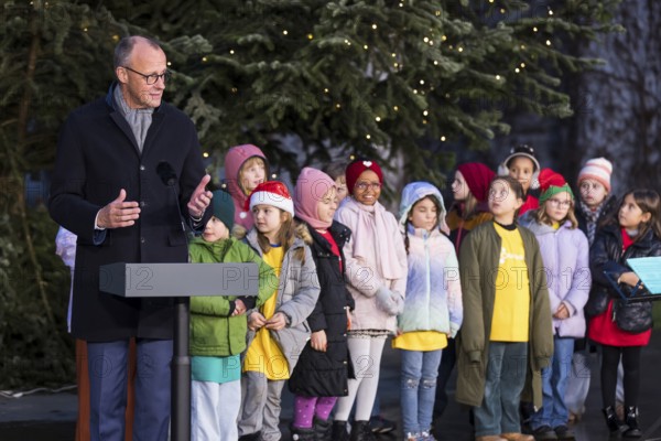 Friedrich Merz (CDU, Federal Chancellor of the Federal Republic of Germany) speaks in front of the Vocal Hero Children's Choir from Schöneberg elementary schools at the handing over of the Christmas tree to the Federal Chancellery, Berlin, 28.11.2025