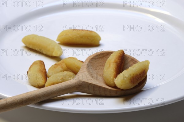 Fried puff noodles with cooking spoon on plate