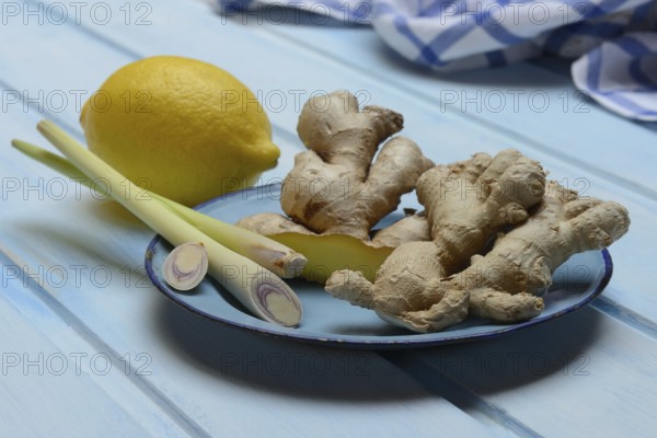 Ginger tubers with lemongrass on plate, lemon