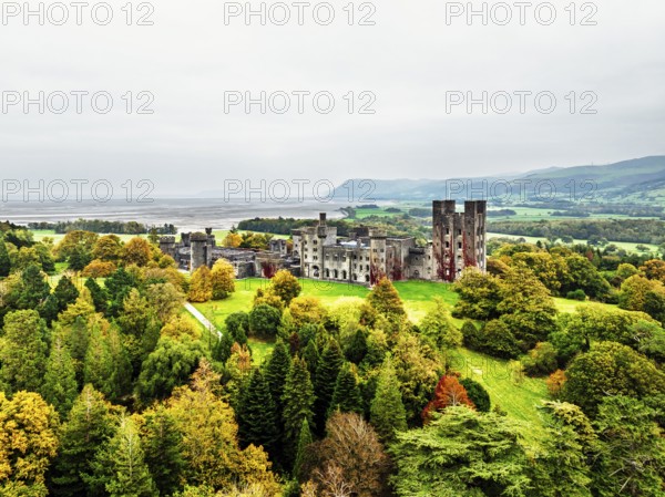 Autumn colours over Penrhyn Castle and Garden from a drone, Llandygai, Bangor, Gwynedd, North Wales, UK