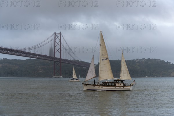 The Ponte 25 de Abril, 3.2 km long bridge in Portugal with a 2278 meter long suspension bridge across the Tagus, cloudy and rainy weather, third-longest suspension bridge with combined road and rail traffic, Lisbon, Portugal