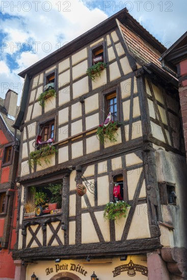 Timber-frame house decorated with vehicles in the historic old town of Riquewihr, Ellsass
