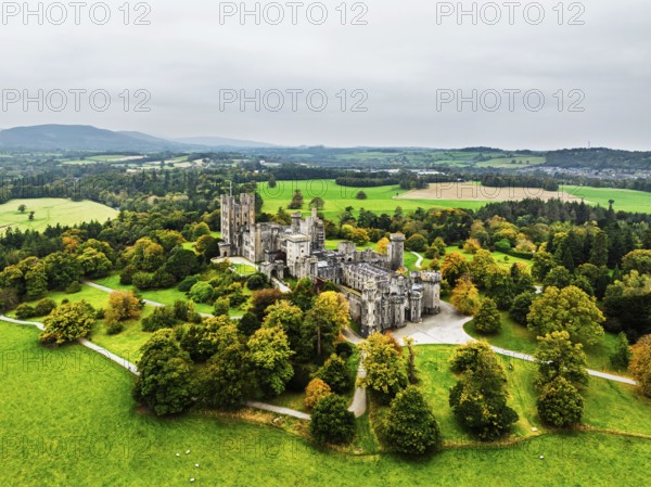 Autumn colours over Penrhyn Castle and Garden from a drone, Llandygai, Bangor, Gwynedd, North Wales, UK