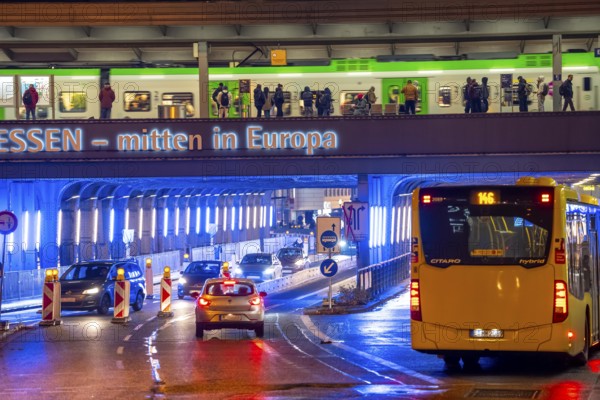 The main train station in Essen, blue illuminated underpass, bus station, am Europaplatz, train on the platform, North Rhine-Westphalia, Germany