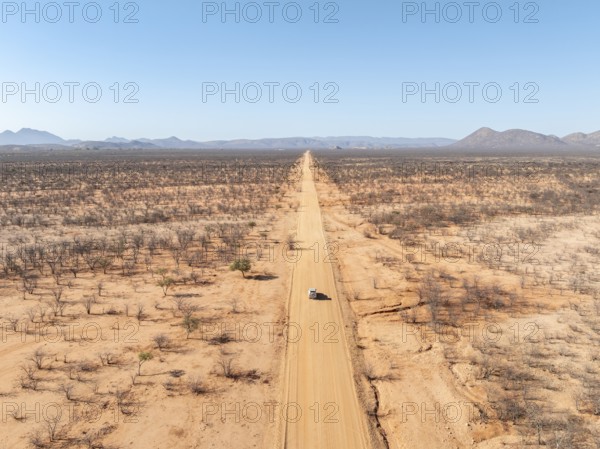 Travel, aerial view, car driving on road through arid landscape, Kunene region, Namibia