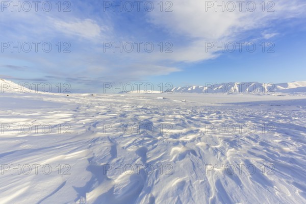 Desolate windswept snow covered Arctic landscape at Mohnbukta, bay at the western shore of Storfjorden in Sabine Land at Spitsbergen, Svalbard