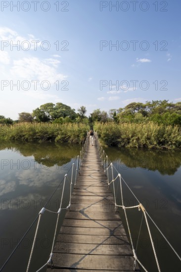 Toruist on the Kavango River, suspension bridge at Camp Kwando, Zambezi region, Caprivi Strip, Namibia