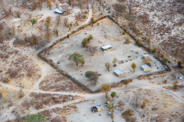 Settlement, simple house and fence, dry savanna landscape, near Maun, aerial view, Okavango Delta, Botswana