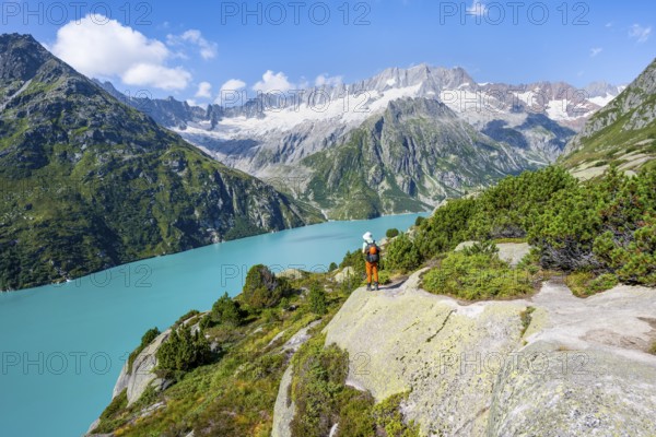 Mountaineers in front of picturesque mountain landscape, turquoise-blue mountain lake Göscheneralpsee, Dammastock and Damma Glacier, Göscheneralp, Canton of Uri, Switzerland