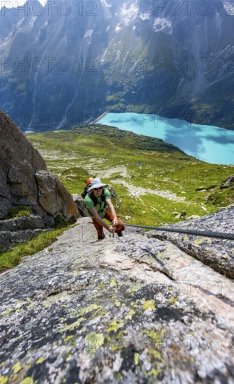 Mountaineer climbs on the secured Schijen-Zwärg via ferrata, climb to Bergseehütte, Göscheneralp in the back, Canton of Uri, Switzerland