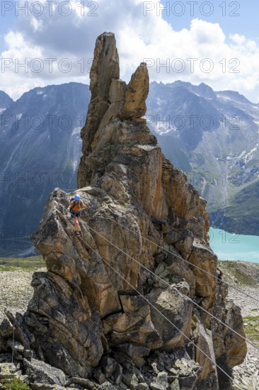 Crocodile rock formation, mountaineer on rope bridge in the Crocodile Mountain Lake via ferrata on Bergseeschijen-Vorbau, Göscheneralp, Canton of Uri, Switzerland