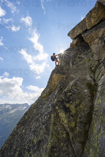 Female mountaineer on steep rock face on the secured via ferrata Krokodil-Bergsee am Bergseeschijen-Vorbau, Sonnenstern, Göscheneralp, Canton of Uri, Switzerland
