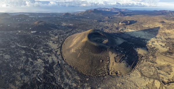 Montaña Negra volcano, picturesque volcanic landscape with volcanic craters and lava fields in morning light, Parque Natural de Los Volcanes, aerial view, Lanzarote, Canary Islands, Spain