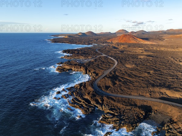 Coast with lava fields, volcanic landscape near Los Hervideros with red volcano Montaña Bermeja, in the evening light, aerial view, Lanzarote, Canary Islands, Spain