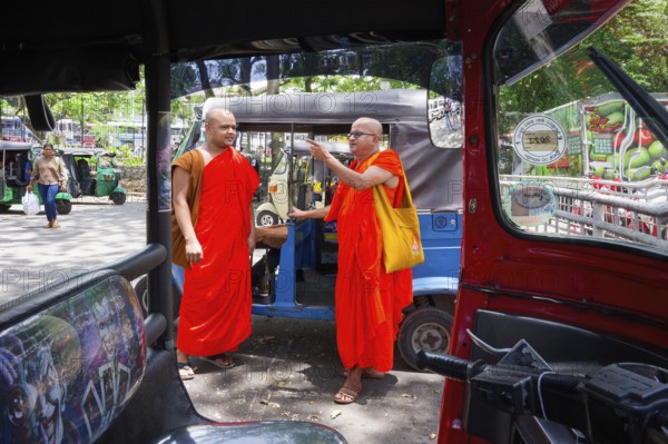 Buddhist monks talking near a tuk-tuk, Kandy, Sri Lanka