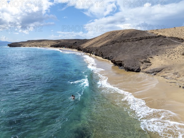 Coast with Playa Caleta del Congrio beach and blue sea, arid landscape of Los Ajaches Natural Park, aerial view, Lanzarote, Canary Islands, Spain
