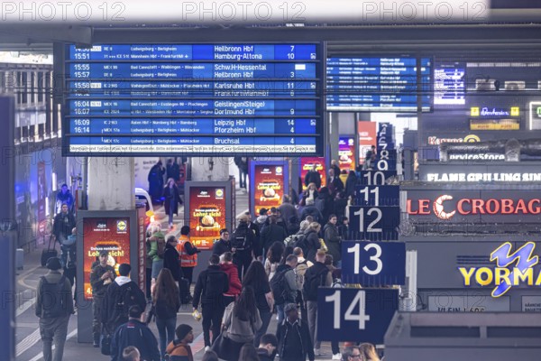 Travelers at the main train station, passengers and departure board at Stuttgart main station. Stuttgart, Baden-Württemberg, Germany