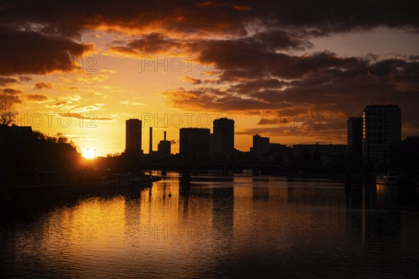 The sun sets behind the Main and Frankfurt Westhafen Tower, Alte Brücke, Frankfurt am Main, Hesse, Germany