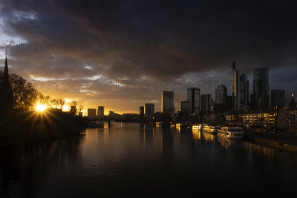 The sun sets behind the Main and bathes Frankfurt's banking skyline in orange-yellow light, Alte Brücke, Frankfurt am Main, Hesse, Germany