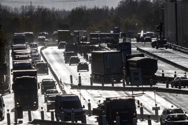 Highway construction site, the A57 is extended to 6 lanes on the section between the Meerbusch motorway junction and the Oppum junction, traffic runs parallel to 2 narrowed lanes, wet road after rain shower, Krefeld, North Rhine-Westphalia, Germany