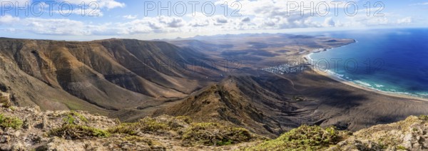 Panorama at Castillejo viewpoint, view from the Risco de Famara cliffs to the coast and the sea with Famara beach, Playa de Famara with La Calaeta, Lanzarote, Canary Islands, Spain