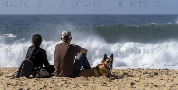 Tourists watch the waves of the Atlantic on the rocky plateau of Sito, also known as Forte São Miguel, a surfing paradise with monster waves in the months of November to February, Nazaré, Portugal