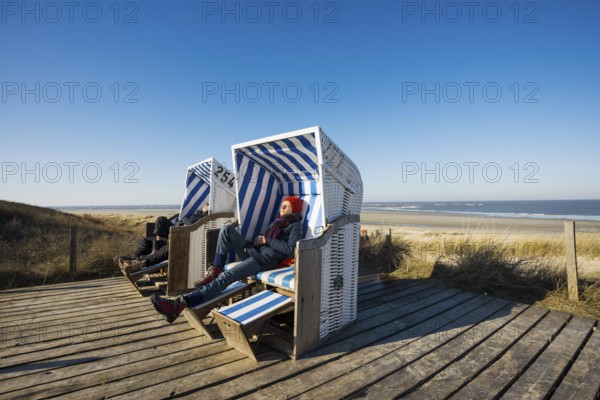 Beach chairs in the dunes and blue sky in winter, Spiekeroog, East Frisian Islands, Lower Saxony, Germany