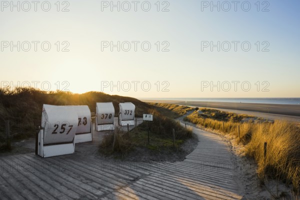 Beach chairs in the dunes and blue sky in winter, sunset, Spiekeroog, East Frisian Islands, Lower Saxony, Germany
