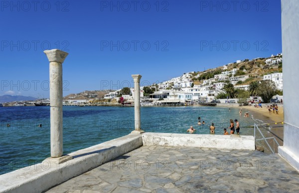 Mykonos, Cyclades, Greece - Tourists and locals like to bathe at the small town beach Paralia Cheras Mikonou right at the old port in the old town of Mykonos Town, Mykonos Chora. Mykonos is part of the Cyclades archipelago