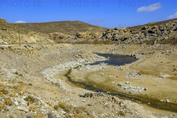 Mykonos, Cyclades, Greece - Dry Fokos Reservoir near Ano Mera. The Mykonos Municipal Water Supply and Sewage Management Company has two dams, Marathi Reservoir and Fokos Reservoir, to supply water to the island. Due to the prolonged drought, both are almost empty and are not being used