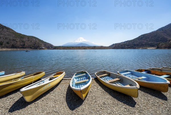 Rowing boats on shore, view across the lake to Mt Fuji volcano, Motosu Lake, Yamanashi Prefecture, Japan