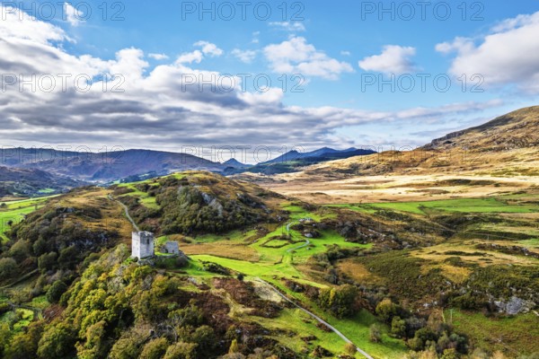 Autumn colours over Castell Dolwyddelan and Eryri Mountains from a drone, Snowdonia, Conwy County Borough, Wales, England, United Kingdom