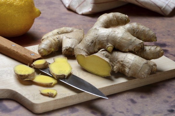 Ginger, ginger root cut with ginger slices on wooden boards