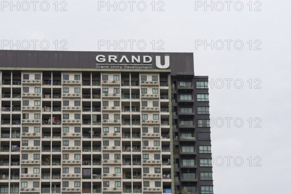 Exterior façade of a residential high-rise building of Condo U (a brand or series name of the Thai real estate developer Grand Unity Development Co., Ltd. (often abbreviated Grand U), Bangkok Yai district, the old town of Bangkok, Thailand