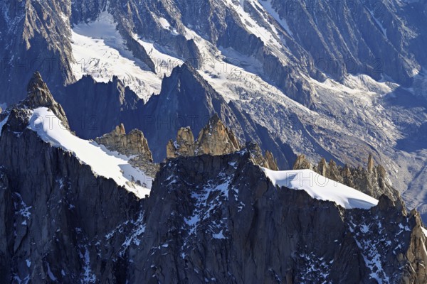 Rugged rocks jut out of a snow-covered mountain, viewing platform, Aiguille du Midi mountain station, Chamonix-Mont-Blanc, Haute-Savoie, France