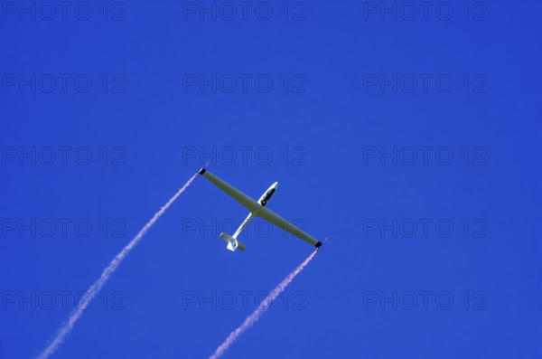 An SZD-59-1 ACRO glider, registration D-1138, during a demonstration as part of an air show at the Fliegerbergfest of the Rossfeld Luftsportverein in Metzingen-Glems, Baden-Württemberg, Germany, for editorial use only