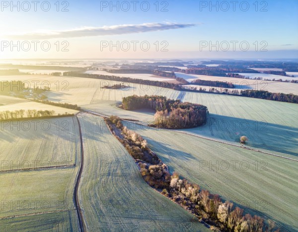 Bird Eye Perspective of Frost Covered Farmland. Seasonal Agricultural Scenery, winter and autumn scene, blue sky with golden light at sunrise, AI generated